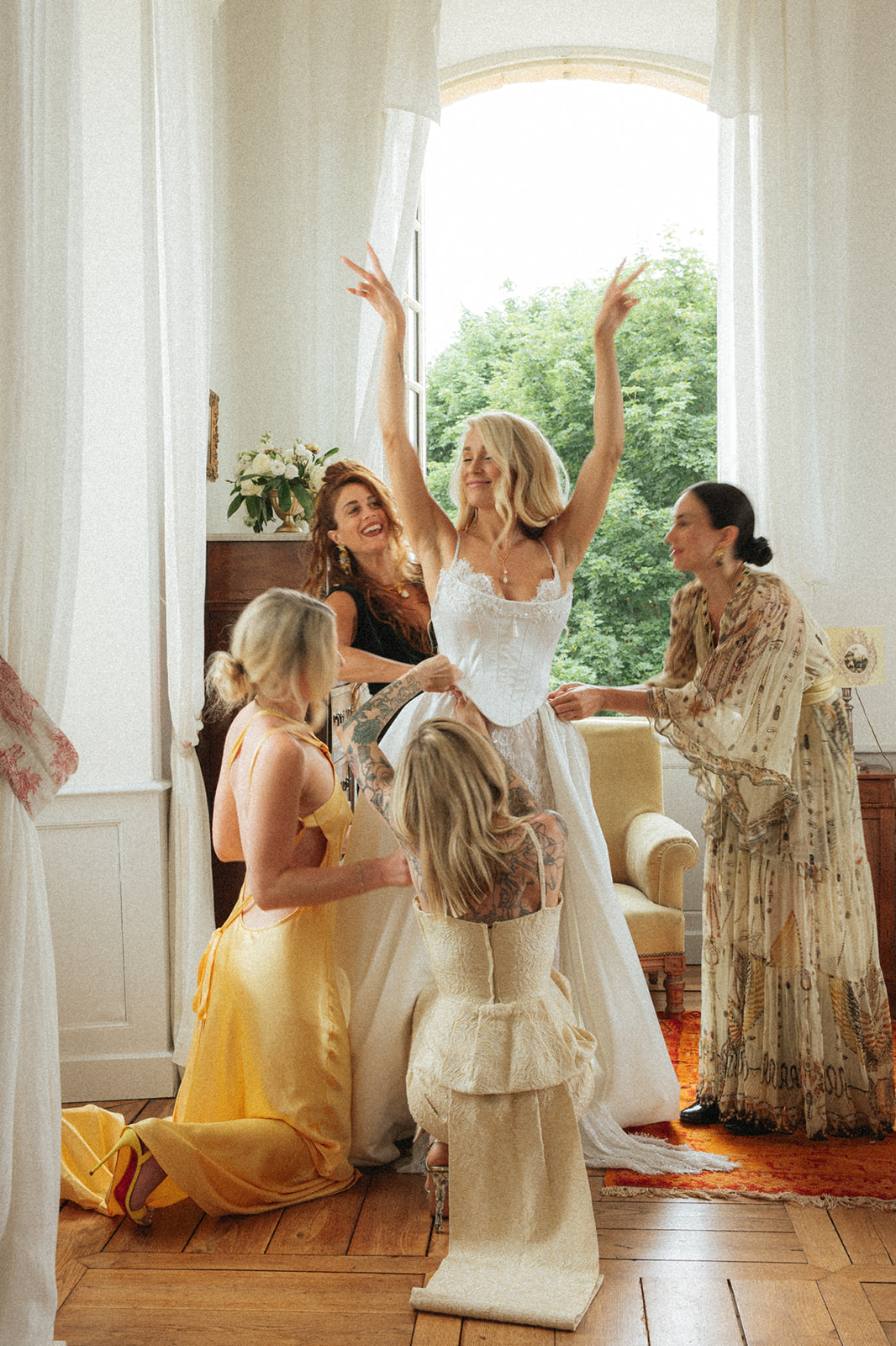 Bernadeta Kupiec, Italy wedding photographer bride putting on her dress with bridesmaids