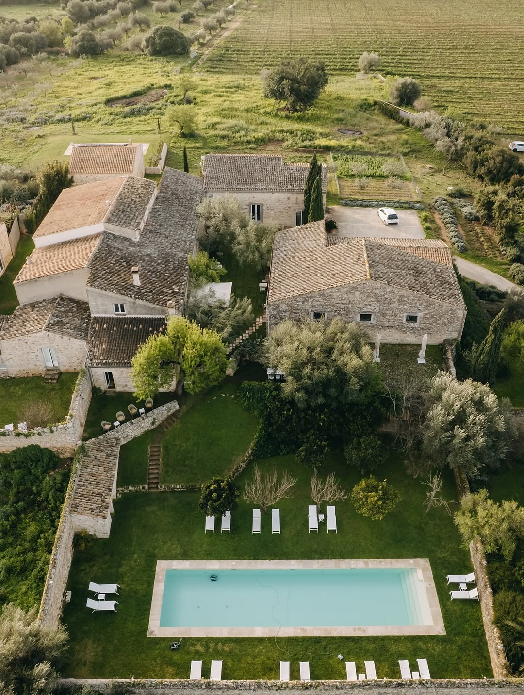 Italian Sicily wedding venue, historic stone farmhouse, mediterranean fields countryside, modern swimming pool