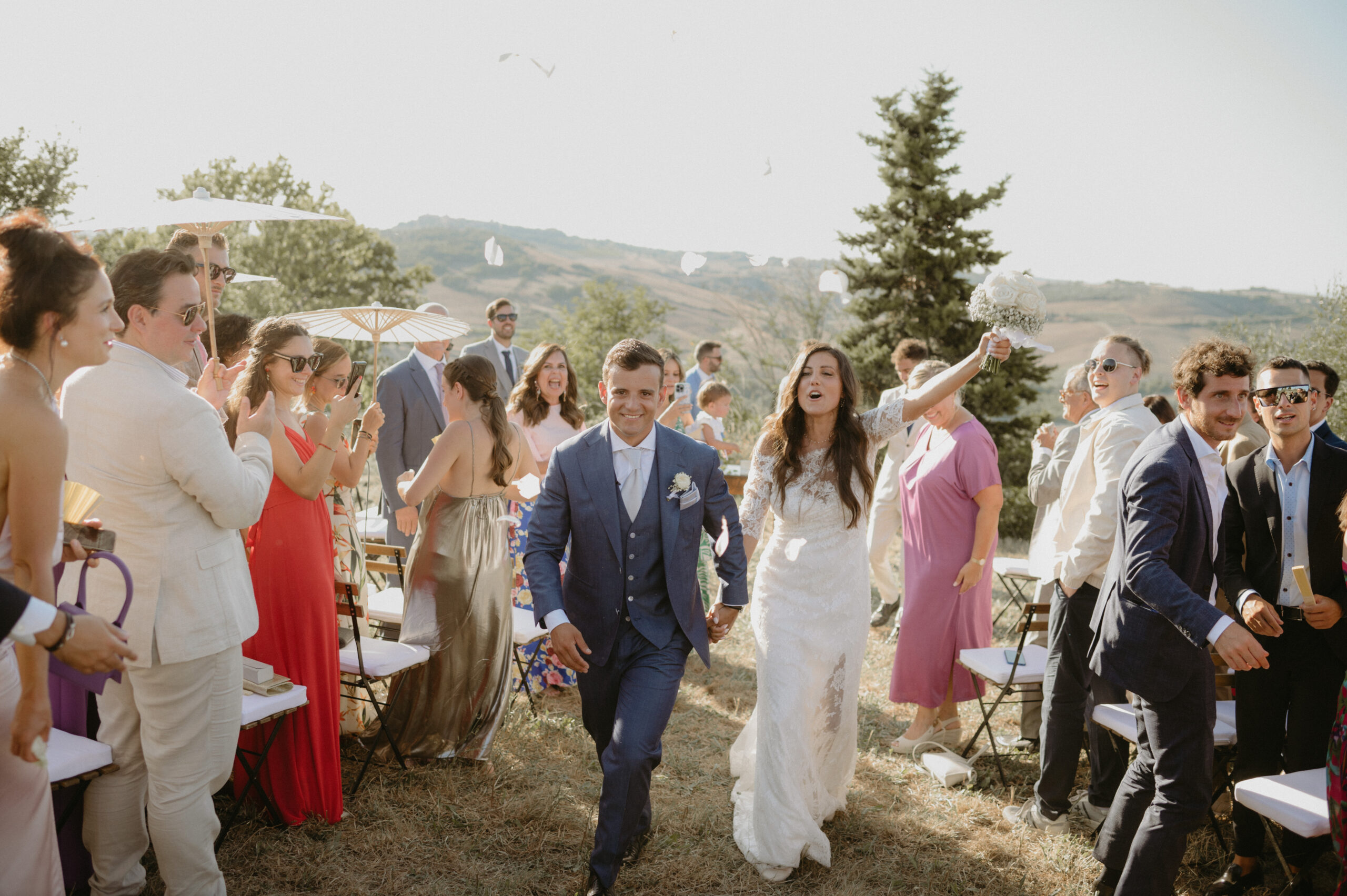 We Wedding in Tuscany, Italian wedding planner couple walking through guests at outdoor ceremony